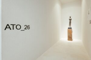 Parede de identidade do ambiente ATO_26 com escultura em bronze ao fundo, CasaCor RS 2026