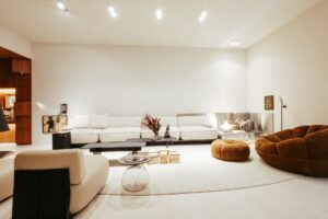 Living do ambiente ATO_26 com sofá, poltrona em bouclé e móvel de marcenaria com obras de arte, CasaCor RS 2026