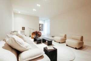 Living do ambiente ATO_26 com sofá branco, poltronas bege e poltrona em bouclé, CasaCor RS 2026
