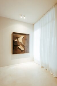 Obra de arte em técnica mista junto à cortina de linho do ambiente ATO_26, piso contínuo em Chukum, CasaCor RS 2026