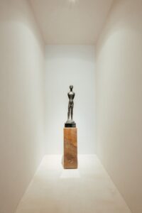 Escultura em bronze sobre pedestal em pedra no ambiente ATO_26, de Juarez Cruz, CasaCor RS 2026