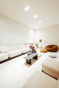 Vista ampla da sala de estar do ambiente ATO_26, com sofá, poltrona em bouclé e mesa de centro, CasaCor RS 2026