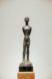 Detalhe da escultura em bronze de figura humana no ambiente ATO_26, de Juarez Cruz, CasaCor RS 2026