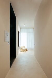 Vestíbulo de entrada do ambiente ATO_26, com painel informativo e peça coberta junto à janela, CasaCor RS 2026